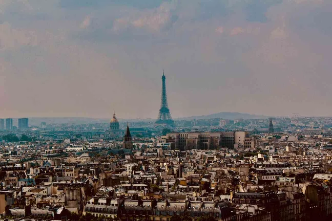 Vue panoramique de Paris avec la Tour Eiffel au loin, offrant un paysage urbain emblématique de la capitale française.